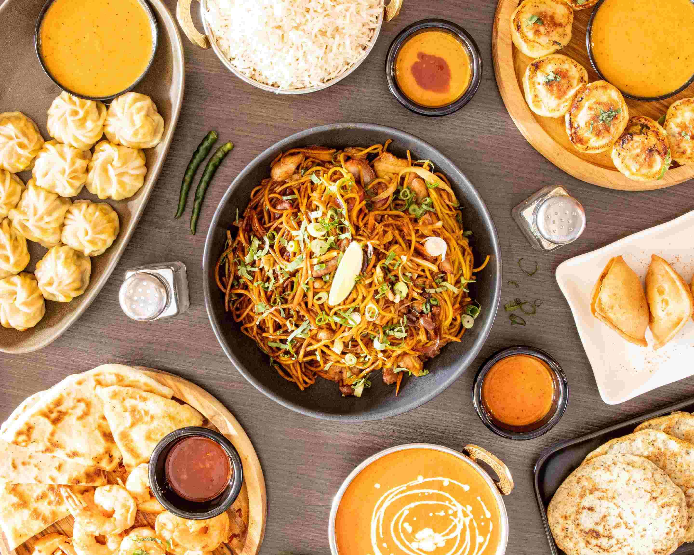 Momo King food spread — momo, chowmein, curry and chutneys