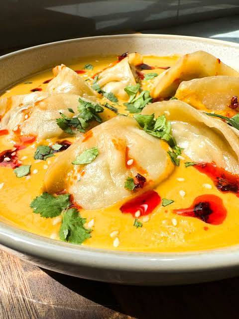 Veg Jhol Momo — momos in yellow jhol with chili oil